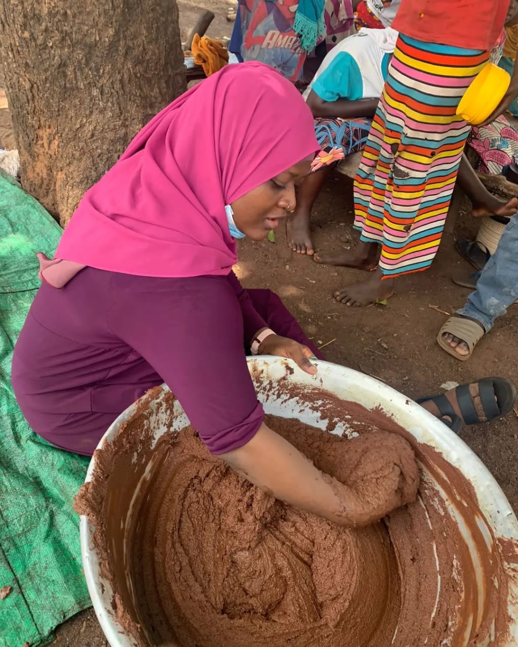 Woman kneading raw shea butter paste by hand, Tamale, Northern Ghana